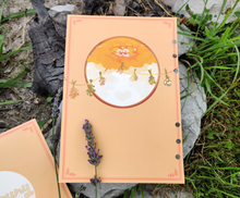 Load image into Gallery viewer, The back cover consists of two yukinkos snuggled in an autumn tree. They provide the most important ingredient to the soup: love. There are hanging herbs extending from the tree to the edges of the page. These should match up with the front page.
